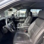 A black truck with leather seats and steering wheel.