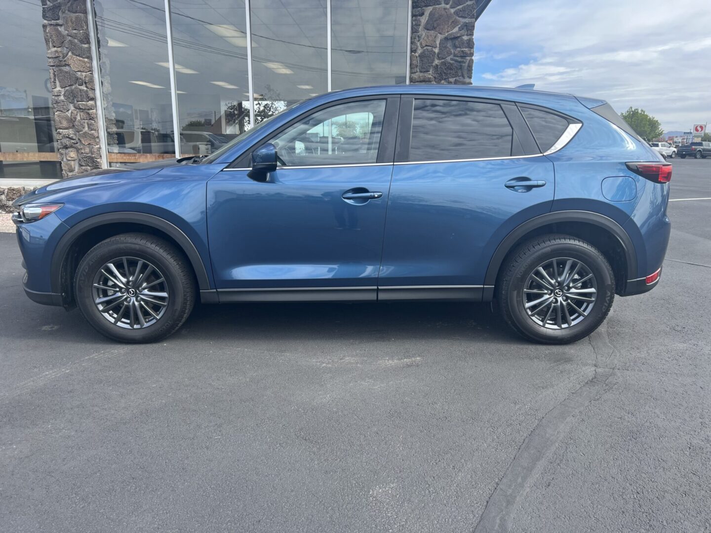 A blue mazda parked in the parking lot.