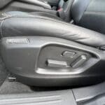 A car seat with the door open and the front seats closed.