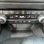 A car 's dashboard with buttons and knobs.