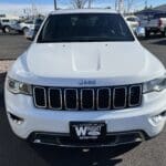 A white jeep grand cherokee parked in a parking lot.