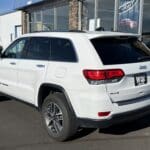 A white jeep parked in front of a building.