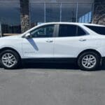 A white suv parked in front of a building.