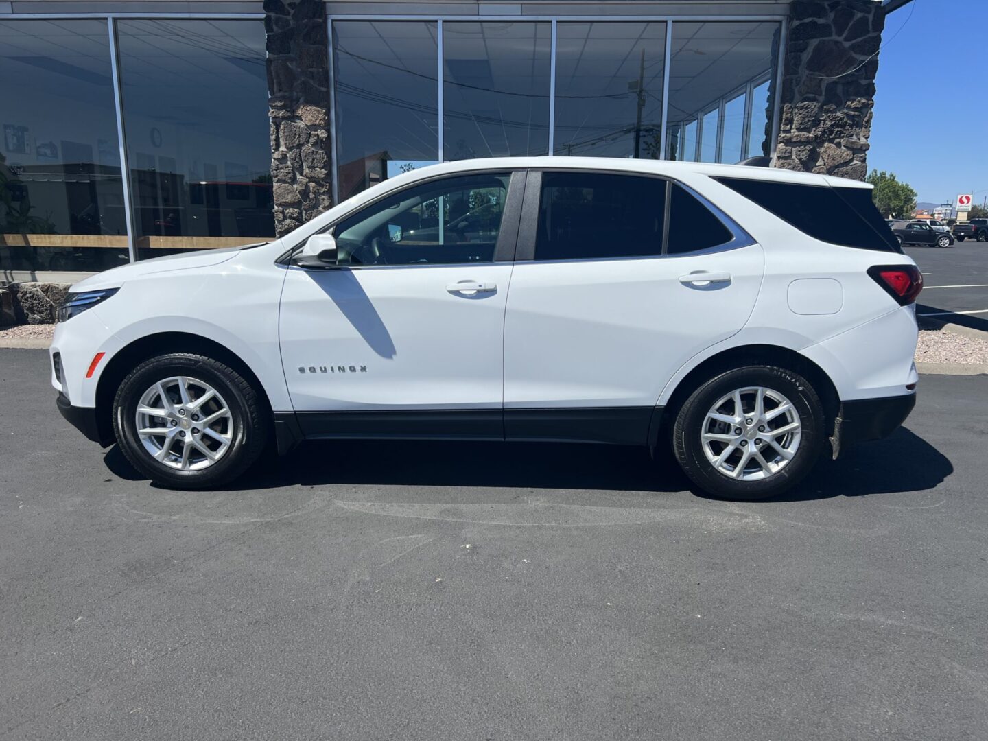 A white suv parked in front of a building.