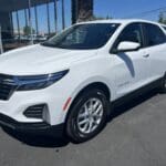 A white car parked in the parking lot of a building.