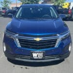 A blue car parked in the parking lot of a shopping center.