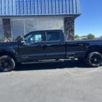 A black truck parked in front of a building.