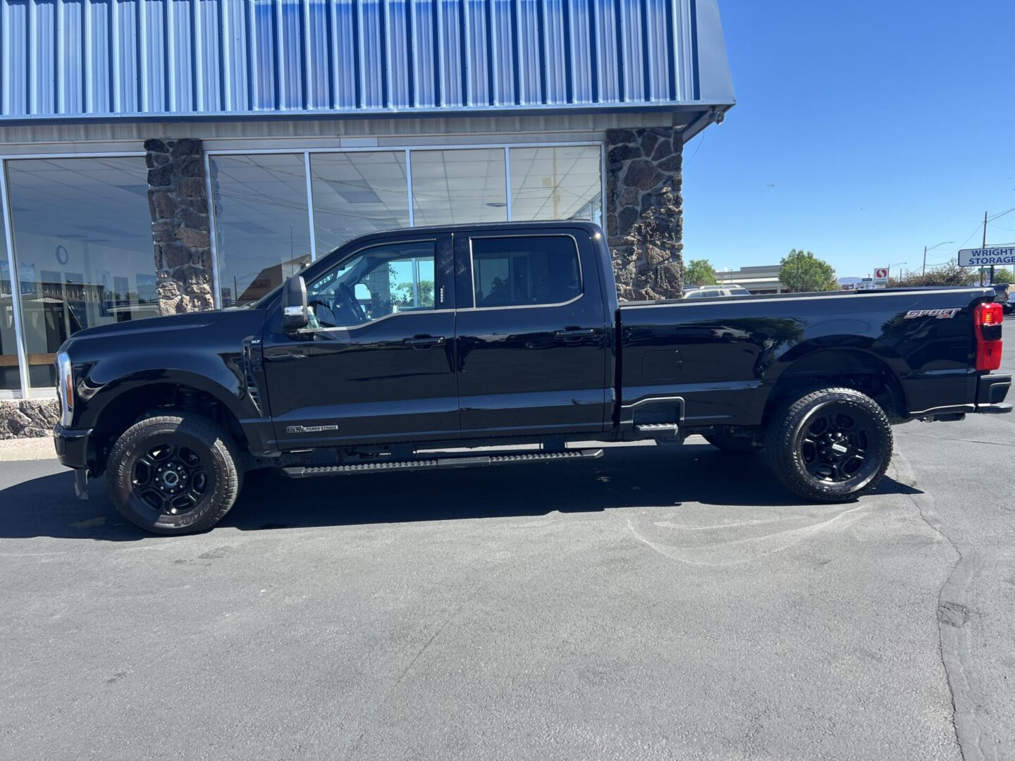 A black truck parked in front of a building.