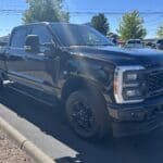 A black truck parked on the side of a road.