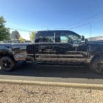 A black truck parked on the side of a road.