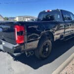 A black truck parked on the side of a road.