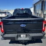 A black truck parked in the lot with other vehicles.