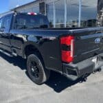 A black truck parked in front of a building.