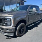 A silver truck parked in front of a building.