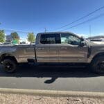 A silver truck parked on the side of a road.