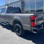 A gray truck parked in front of a building.