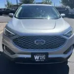 A silver ford edge parked in a parking lot.