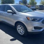 A silver ford edge parked in a parking lot.