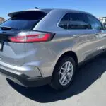 A silver ford edge parked in the parking lot.