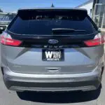 A silver ford escape parked on the side of a road.