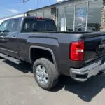 A black truck parked in front of a building.