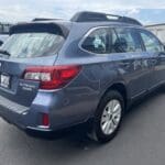 A blue subaru outback parked in the parking lot.