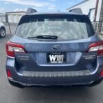 A blue subaru parked in the lot with other cars.