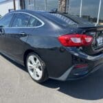 A black car with its trunk open in the parking lot.