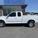 A white truck parked in front of a building.