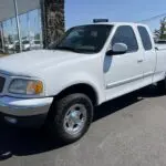 A white truck parked in front of a building.