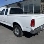 A white truck parked in front of a building.