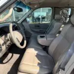 A truck with the driver and passenger seats in front of a window.