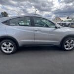 A silver car parked in the lot with other cars