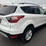 A white suv parked on the side of a road.