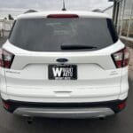 A white suv parked on the side of a road.