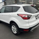 A white suv parked in front of a building.