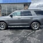 A gray suv parked in front of a building.