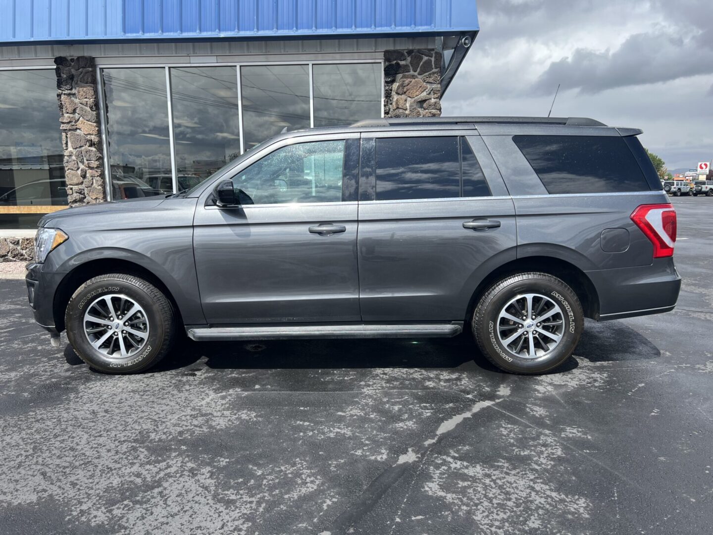 A gray suv parked in front of a building.