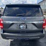 A gray suv parked on the side of a road.