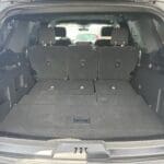 A trunk of a car with the seats folded down.