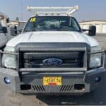 A white truck with its hood up parked in the parking lot.