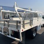 A white truck with a cage on the back of it.