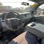 A truck with the driver 's seat up and the steering wheel in view.