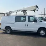 A white van with a crane on the back of it.