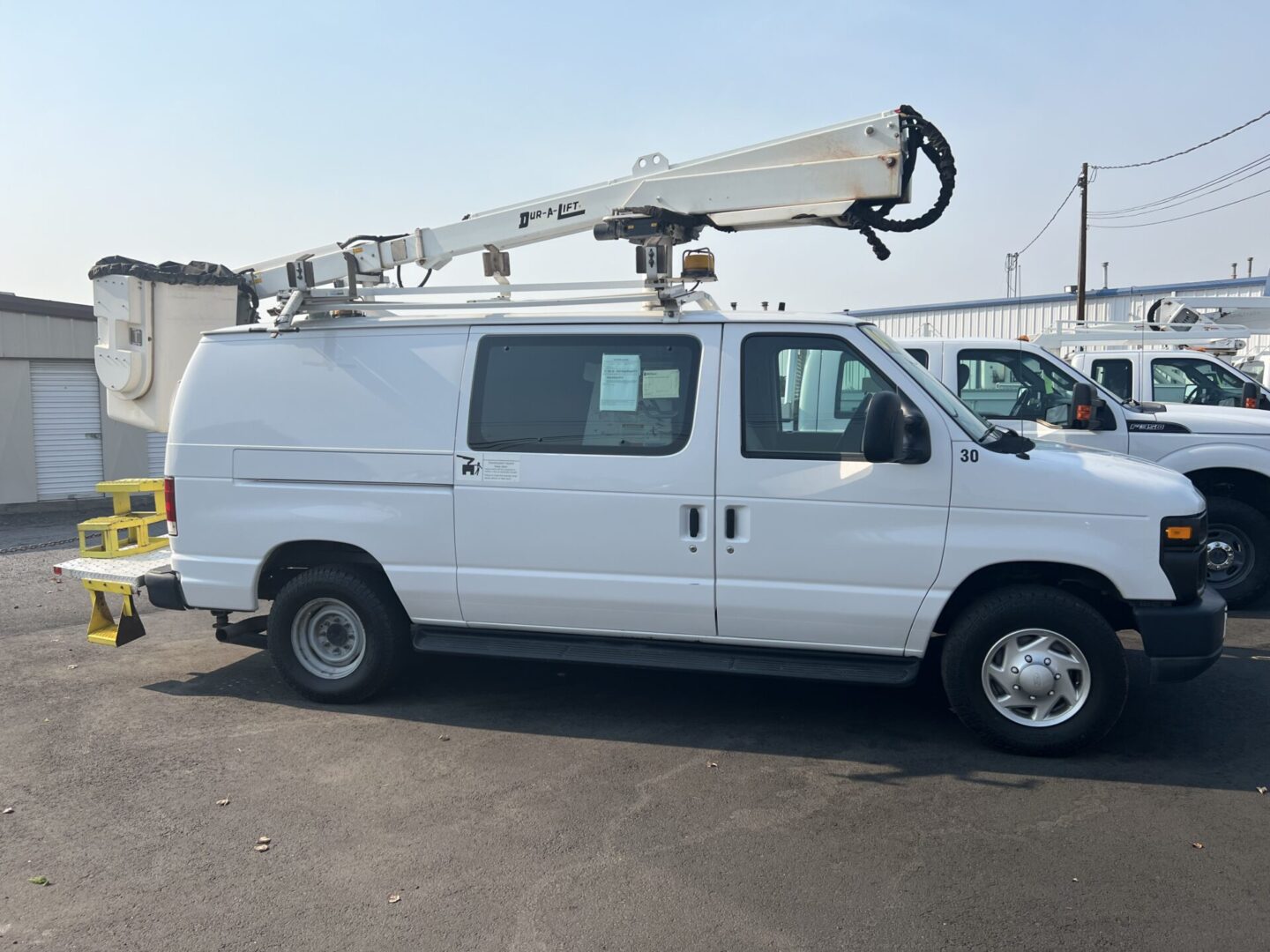 A white van with a crane on the back of it.